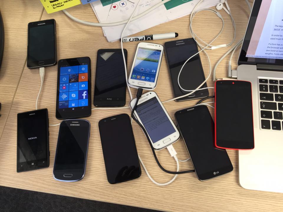 A picture of a group of different mobile phones on a desktop, used for testing the app on real devices.